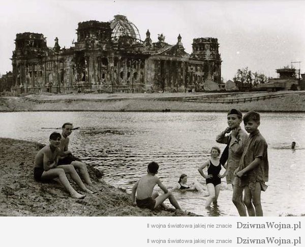 Młodzi ludzie zażywają kąpieli obok zrujnowanego Reichstagu. Berlin 1945
